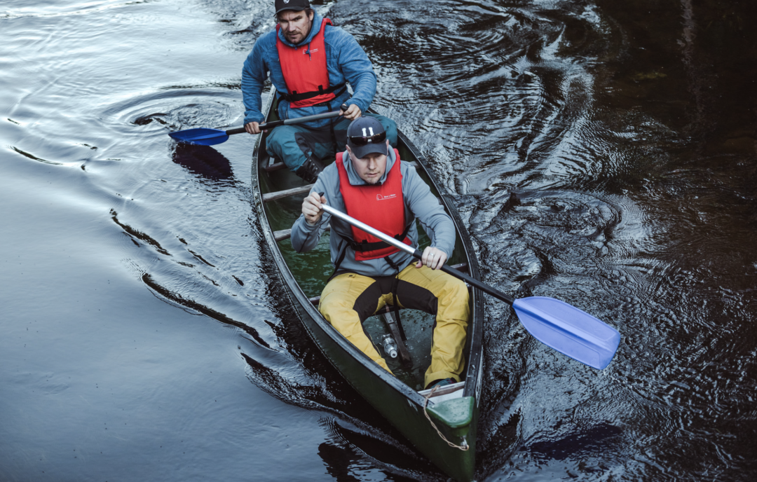 Two people on a canoe focused going in a stream of Pyhäjoki 