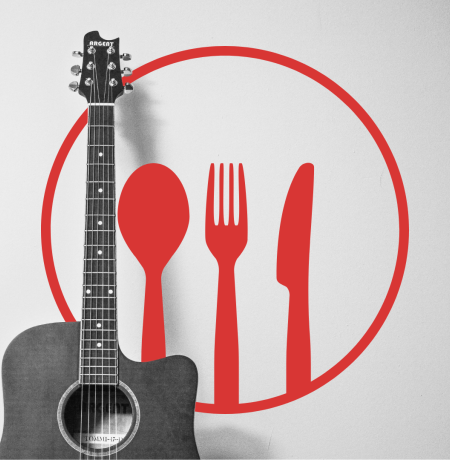 Kitara vaaleaa seinaa vasten sekä lusikka, veitsi ja haarukka