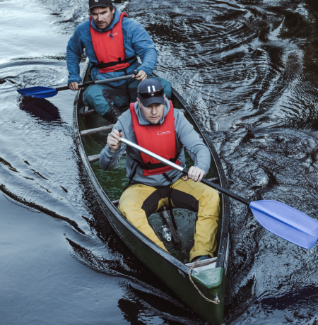 Two people on a canoe focused going in a stream of Pyhäjoki 