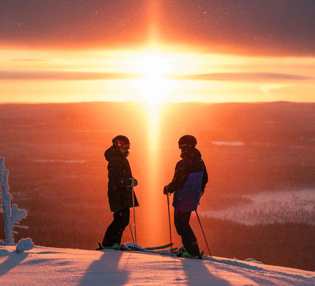 Two skiers at Pyhä Ski Resort Lapland in sunset
