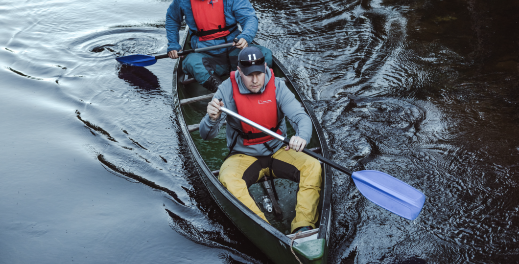 Two people on a canoe focused going in a stream of Pyhäjoki 